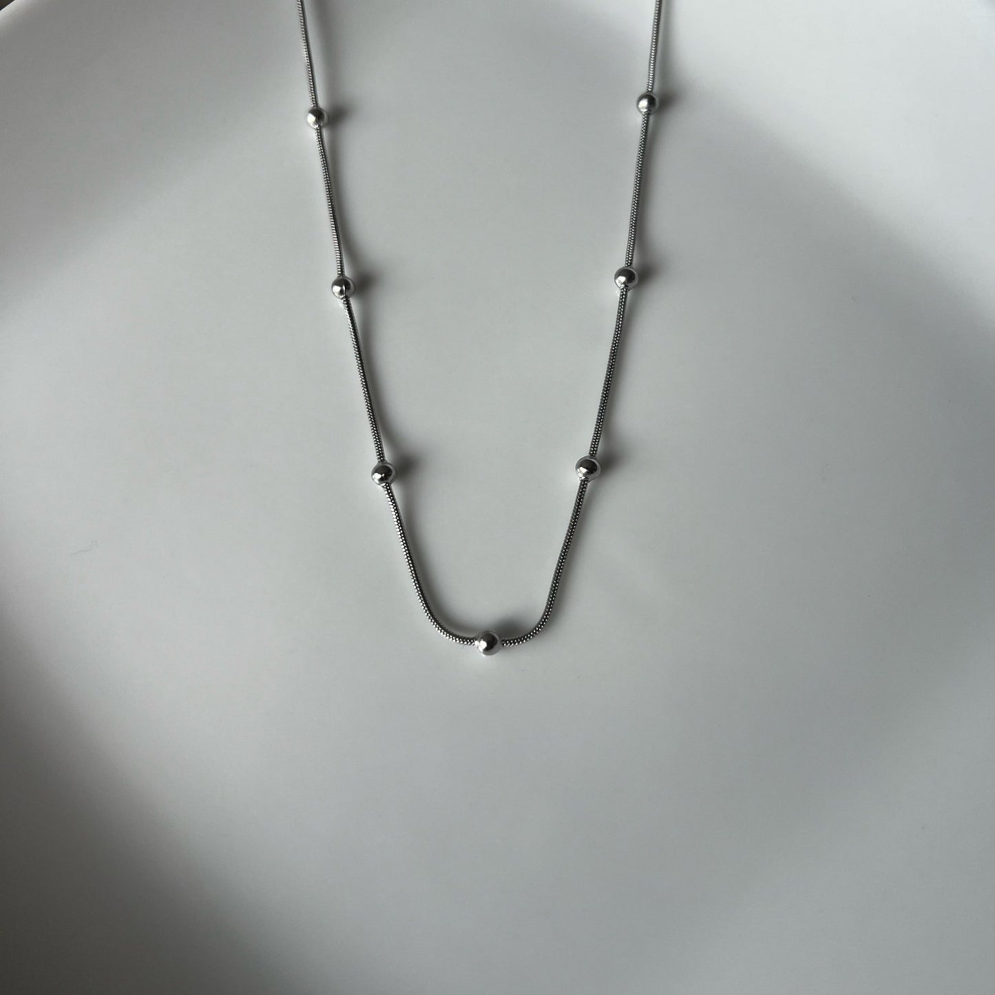 Sphere chain necklace in stainless steel featuring smooth, round spheres on a sleek chain.