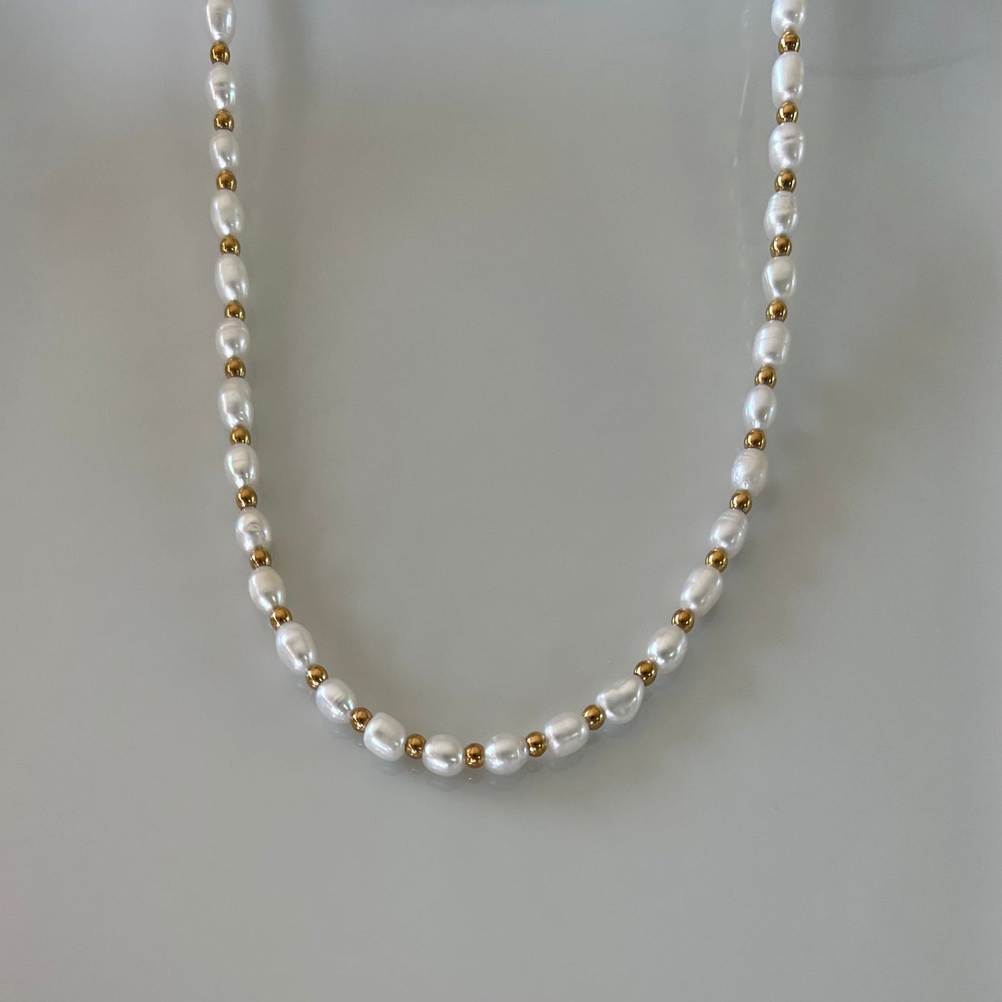 Elegant Hiramyz freshwater pearl necklace with gold beads between each pearl.