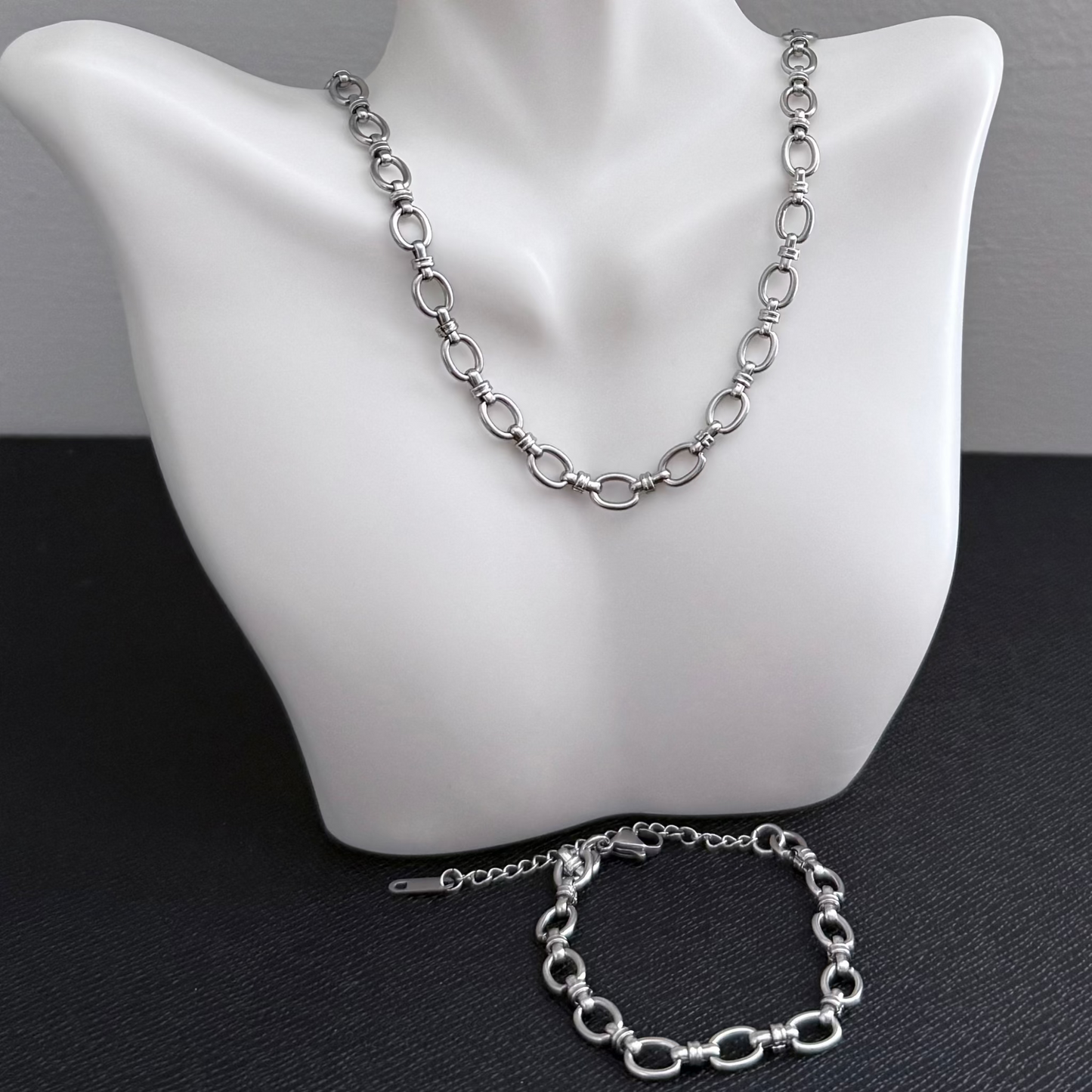 Silver chain necklace and bracelet on a mannequin bust.