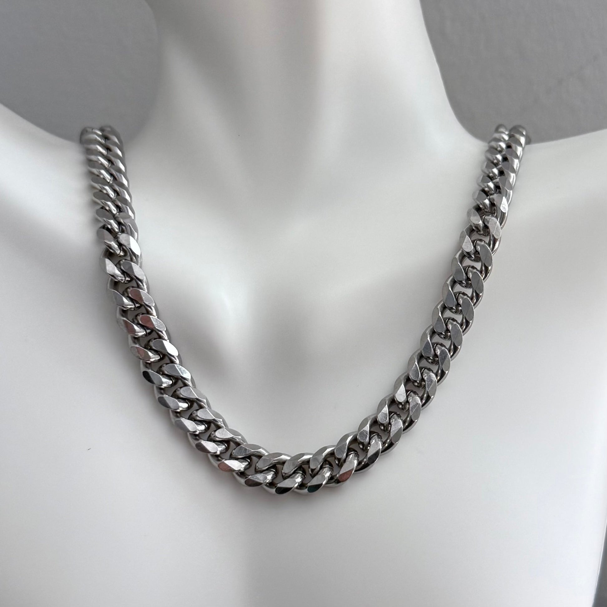 Cuban Chain Silver chain necklace on a mannequin with a plain background.