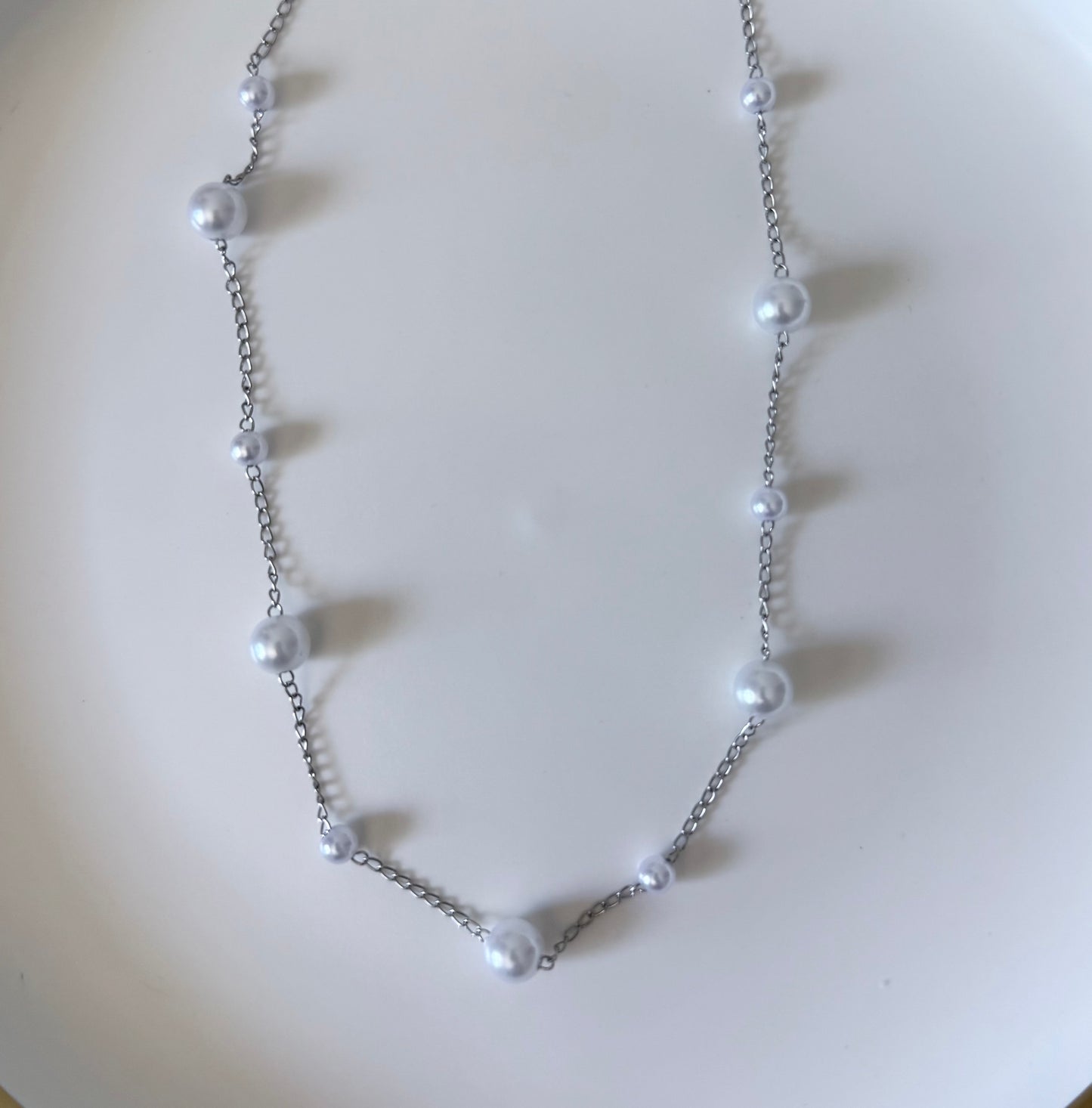 Pearl necklace on a light beige background