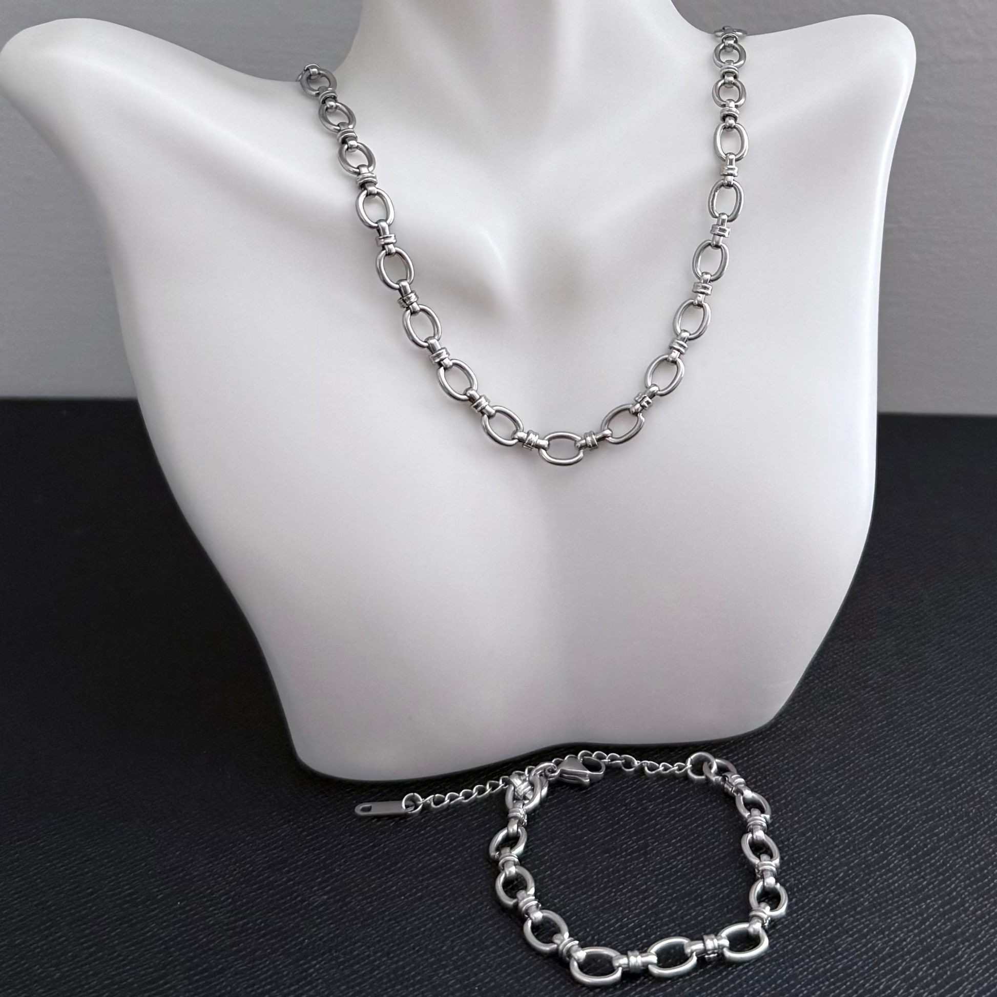 Silver chain necklace and bracelet on a mannequin bust.