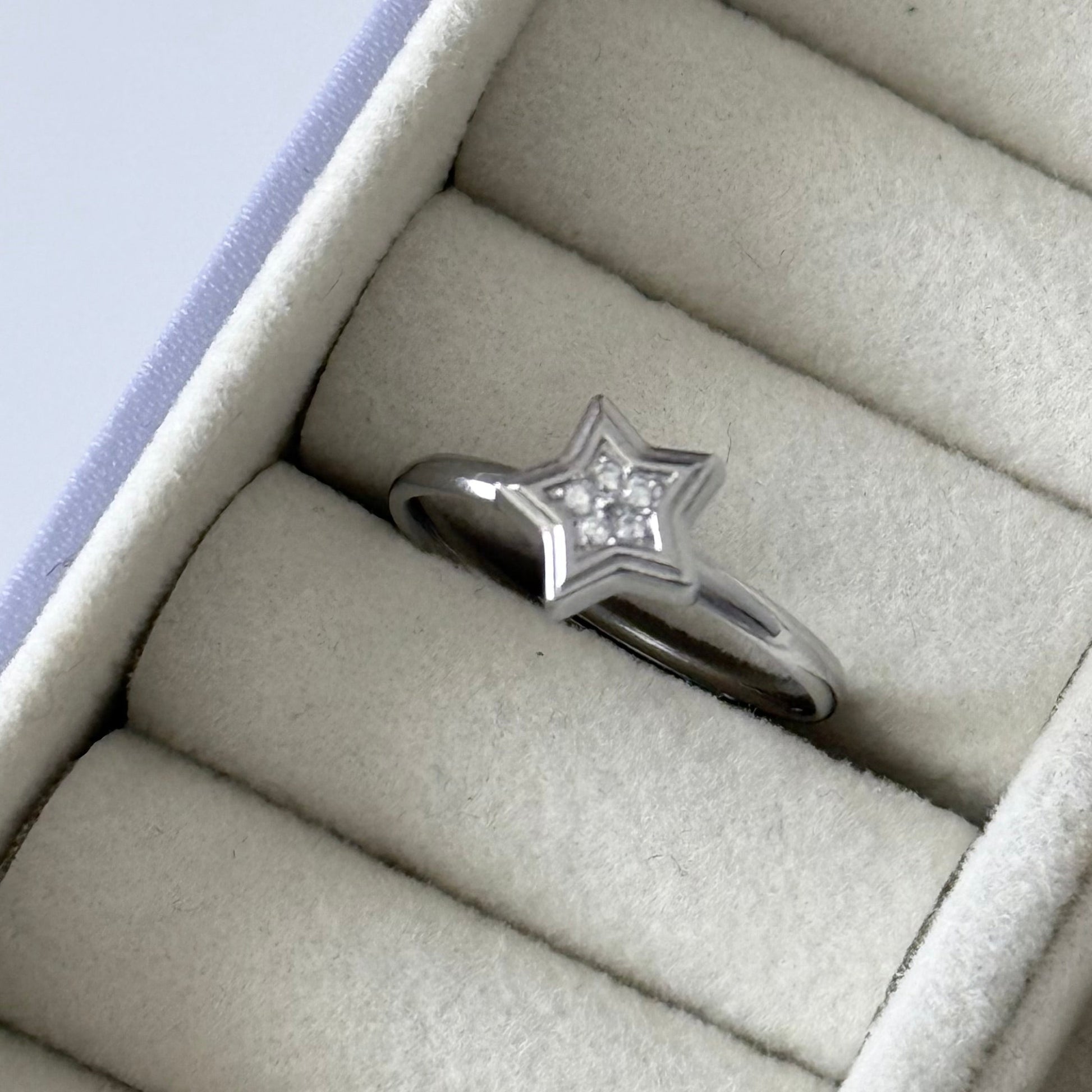 Star-shaped silver ring with a diamond in a jewelry box